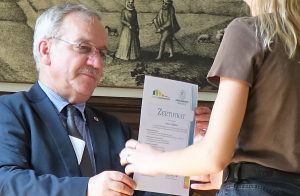Bezirksbürgermeister Tölch (SPD) überreicht ein Zertifikat