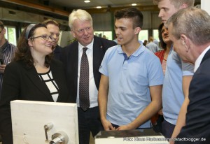 Bundesarbeitsministerin Andrea Nahles besucht Lehrwerkstatt von Thyssen Krupp, Westfalenhütte. Andrea Nahles in der Lehrwerkstatt läßt sich von Auszubildenden Lukas Latussek und Tim Leubecher, blaue Hemden v. l., den Prototypen der selbstdesinfizierenden Türklinke erklären