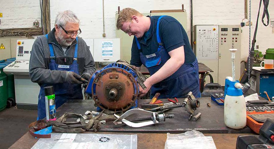 Wolfgang Wiedemann (li.) und Boris Pick bauen den Motor von der Magnetanlage eines Krans auseinander. Foto: Nadine Albach