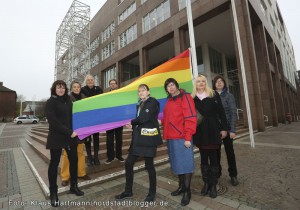 Transidenten-Organisationen Lili Marlene und Transbekannt hissen zusammen mit Unterstützerinnen und Unterstützern Regenbogenfahne am Rathaus