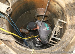 Überschwemmung in Brügmanns Hölzchen im Hoeschpark ist beseitigt. Mitarbeiter von Wilo Pumpen installiert die neue Pumpe im Schacht