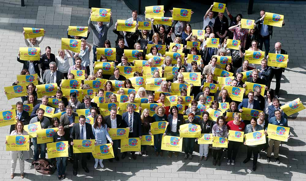 Im Anschluss an die Personalversammlung stellten sich die Mitarbeiter der BIG mit den Kampagnenplakaten „Wir ALLE sind Dortmund“ auf. Foto: BIG/Stephan Schütze