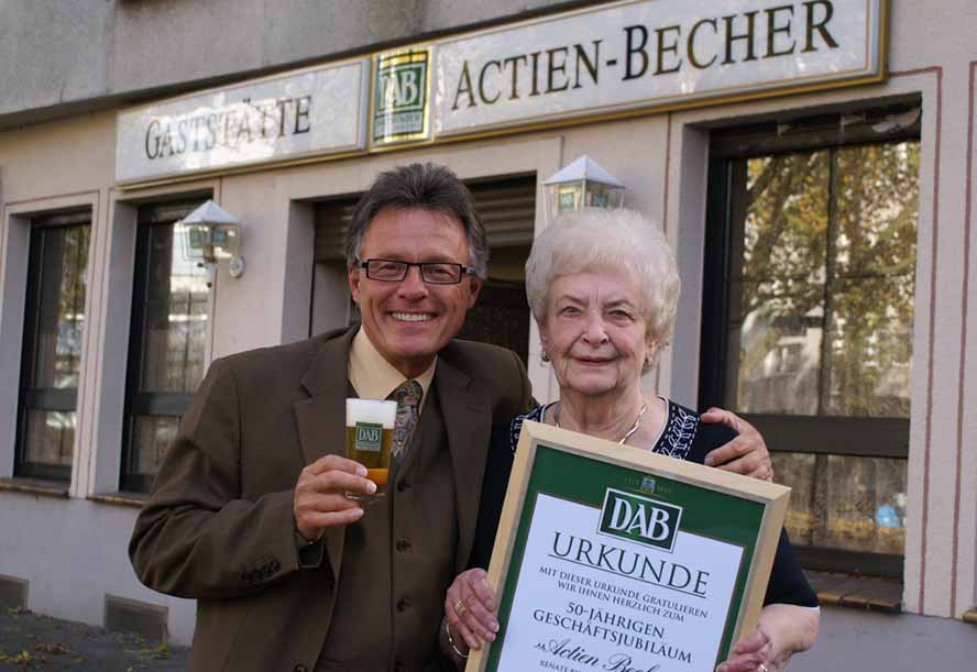 Alexander Olschowka, Verkaufsleiter von den Dortmunder Brauereien, gratulierte Jubilarin Renate Bisterfeld zum 50. Jubiläum als Wirtin im Actien-Becher. Foto: Foto: p:e:w