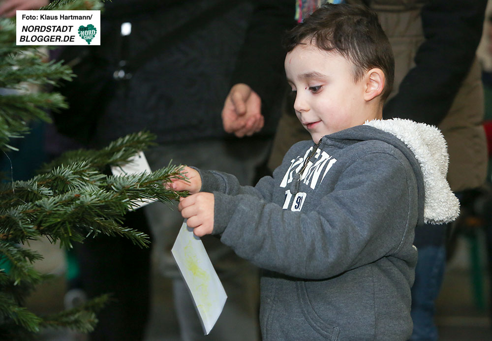 Interkultureller Weihnachtsmarkt im Schleswiger Viertel. Der kleine Fabian hängt seinen Wunsch zum Fest an den Baum