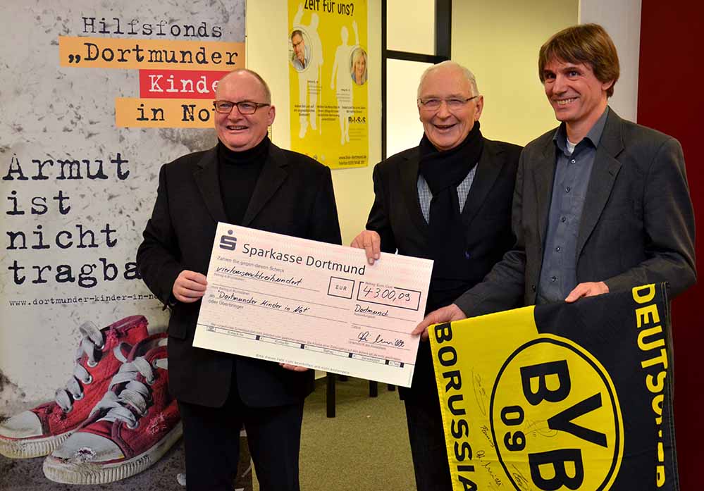 BVB-Legende Aki Schmidt (Mitte) übergab seine Spende für „Kinder in Not“ an Propst Andreas Coersmeier (li.) und Alwin Buddenkotte (re.). Foto: pdp