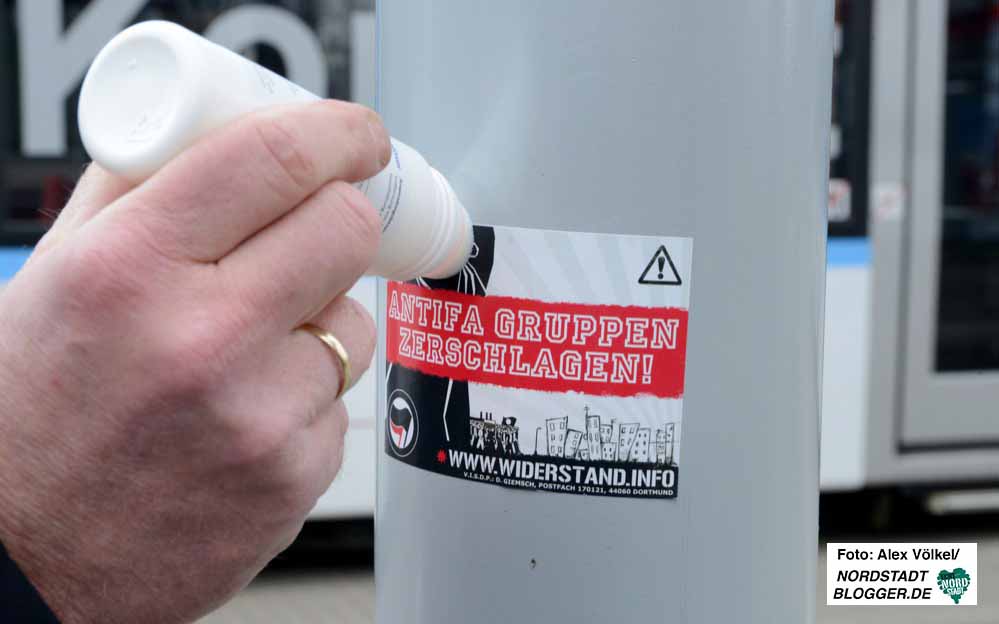 Die Neonazi-Aufkleber werden mit Reinigungsmitteln abgelöst und dann entfernt.