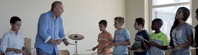 Die Schülerinnen und Schüler der Willkommensklasse 1 an der Anne-Frank-Gesamtschule beweisen in einer Trommel-AG ihr Rhythmusgefühl.