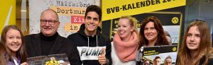 BVB-Abwehrspieler Marc Bartra (3.v.r) unterschrieb im Katholischen Centrum den BVB-Posterkalender. Hier mit Propst Andreas Coersmeier (2.v.r.) sowie jungen Fans und Mitarbeiterinnen vom Katholischen Sozialen Dienst SKM. Foto: pdp