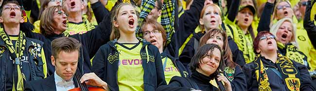 „Kurvenklänge“ - Die Stadionkonzerte. Die Musiker Jan Michels und Laura Wiek (Violoncello) vom Funkhausorchesters inmitten von BVB-Fans. Foto: WDR/Claus Langer