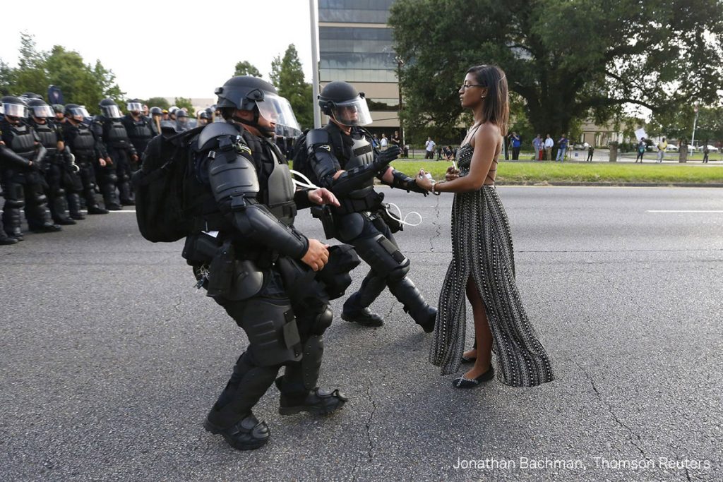 Jonathan Bachman, Reuters Title: Taking A Stand In Baton Rouge Lone activist Ieshia Evans stands her ground while offering her hands for arrest as riot police charge towards her during a protest against police brutality outside the Baton Rouge Police Department in Louisiana, U.S. on July 9, 2016. Evans, a 27-year-old Pennsylvania nurse and mother to a young boy, traveled to Baton Rouge to protest the shooting of Alton Sterling, a 37-year-black man and father of five, who was shot at close range while being held down by two white police officers. The shooting, captured on cell phone videos, aggravated the unrest that has coursed through the United States for two years over the use of excessive force by police, especially against black men.