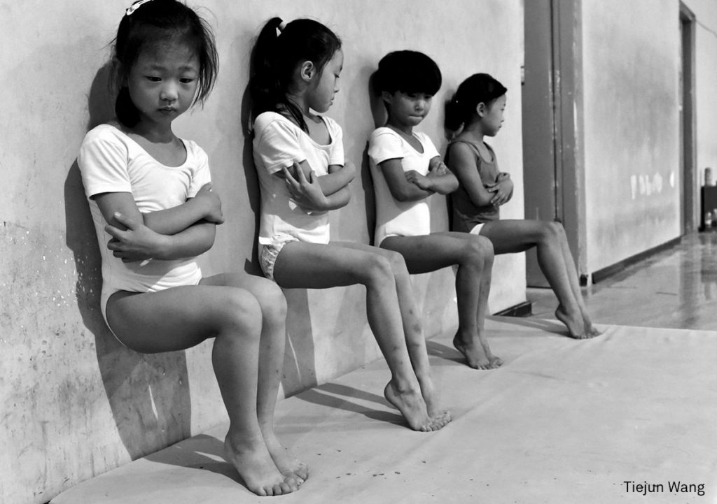 Four students of a gymnastics school in Xuzhou, China, do toe-pressure training for 30 minutes in the afternoon.