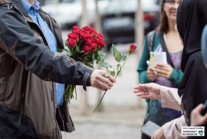 SLADO verteilt zur Feier Rosen in der Dortmunder Innenstadt.