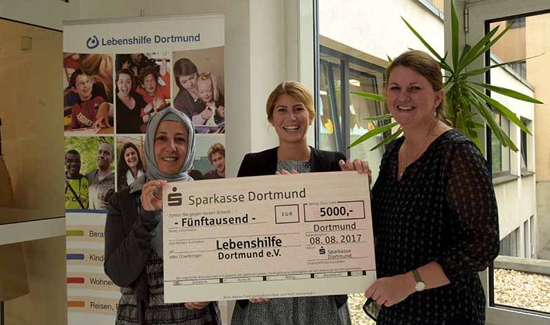 Marielena Bimczok (m.) übergibt den Spendenscheck an Resmigül Acil und Melanie Schütte (v.li.) von der Lebenshilfe Dortmund
