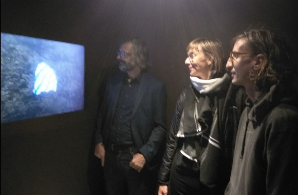 Jürgen Bertling (Fraunhofer Institut Umsicht und Leiter des Festival "Innovative Citizen"), Daniela Berglehn (innogy Stiftung) und der Künstler Sam Hopkins (im Vordergrund) vor einer Video-Präsentation in der Ausstellung