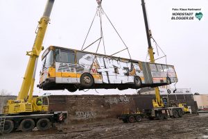 Bus wird am Junkyard über die Mauer gehoben