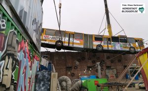 Bus wird am Junkyard über die Mauer gehoben