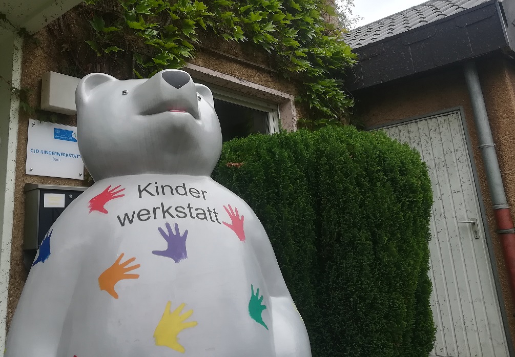 CJD Kinderwerkstatt-Teddybär vor der CJD Jugenddorf Verwaltung