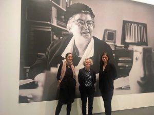 Die Kuratorinnen (v.li.) Caro Delsing, Regina Selter und Karoline Sieg vor einem großformatigen Porträt von Gründungsdirektorin Leonie Reygers.