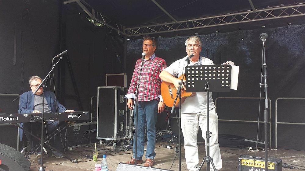 UZ-Pressefest Diether Dehm singt, begleitet von Michael Letz (links) und Hartmut König (rechts)