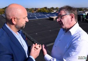 Pascal Ledune und Henk Jan Hoekman im Gespräch auf den Dächern der alten Spinnerei. Im Hintergrund sind die Solarpaneele zu sehen. 