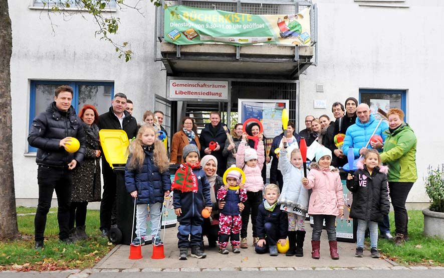 VertreterInnen der Dortmunder Wohnungsgesellschaften und der Kinder- und Jugendeinrichtungen in der Nordstadt bei der Übergabe der Spieletonnen in der Libellensiedlung. Foto: Sascha Fijneman