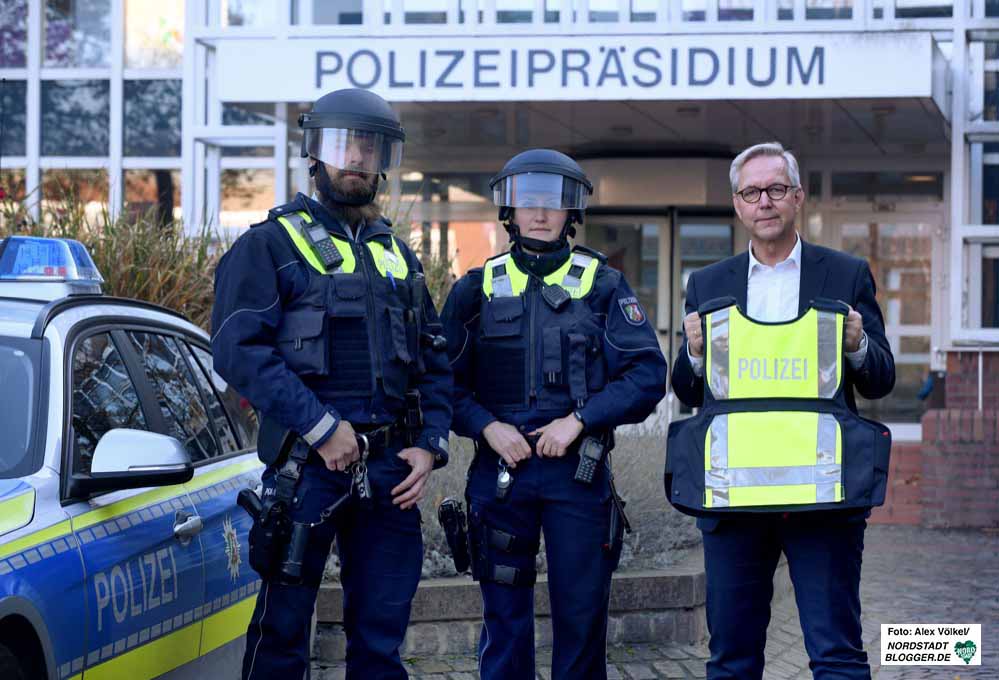 Die Polizeikommissare Ann-Kathrin Ossenkopp und Nils Jäger präsentieren mit Polizeipräsident Gregor Lange die neue Ausrüstung.