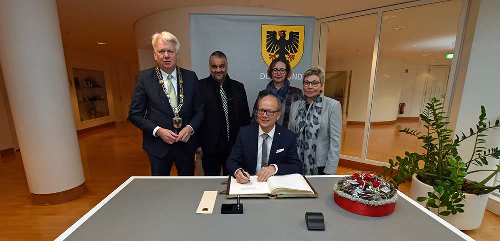 Landtagspräsidium zu Gast in Dortmund: Empfang durch OB Sierau – Eintrag ins Goldene Buch der Stadt Im Januar war das Präsidium des Landtags Nordrhein-Westfalen zu Gast in Dortmund. Dortmunds Oberbürgermeister Ullrich Sierau empfing die Mitglieder im Rathaus der Stadt. Dort trugen sie sich ins Goldene Buch der Stadt Dortmund ein. OB Sierau bedankte sich für die Ehre des Besuchs. „Ich bin froh, dass Sie heute zu uns gekommen sind“, sagte Sierau, der den Gästen in seiner Begrüßung die Stadt unter anderem mit Hinweisen auf den geleisteten Strukturwandel, Dortmunds Nachhaltigkeitsstrategie, ihren Einsatz im Klimaschutz und auf das zivilgesellschaftliche Engagement vorstellte. „Ihr Besuch ist eine gute Gelegenheit, ins Gespräch zu kommen.“ André Kuper, Präsident des Landtags Nordrhein-Westfalen: „Demokratie lebt vom Zuhören und Mitmachen. Deswegen besucht das Präsidium des Landtags Dortmund und andere Städte und Regionen in Nordrhein-Westfalen. Und deswegen würdigen wir bei unserem Besuch Dortmunder, die sich ehrenamtlich engagieren. Sie sind die gute Seele der Gesellschaft und eine Stütze unserer Demokratie.“ Im Rahmen ihres Besuchs informieren sich die Präsidiumsmitglieder in vielen Gesprächen über die Stadt Dortmund und ihre Entwicklung. Auf der Tagesordnung stehen unter anderem ein Besuch auf PHOENIX-West mit Informationen über Start-ups, die Besichtigung des PHOENIX-Sees mit einem inhaltlichen Schwerpunkt zur Wohnungspolitik der Stadt Dortmund, ein Besuch der Sparkassenakademie sowie Gespräche bei der Agentur „Willkommen in Europa“ in der Nordstadt. Am Abend empfängt das Präsidium ehrenamtlich Tätige aus Dortmund im Rathaus.