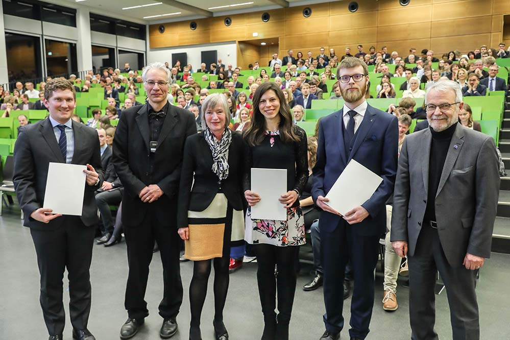 Ein Beitrag zur Nachwuchsförderung Till-Moritz-Karbach-Preis geht an drei Nachwuchswissenschaftler der TU Dortmund Der Till-Moritz-Karbach-Preis wurde in diesem Jahr an eine Nachwuchswissenschaftlerin und zwei Nachwuchswissenschaftler verliehen, Sie teilen sich den Preis. Am Samstag, 2. März, zeichneten die Stifter des Preises, das Ehepaar Jutta und Walter Karbach, zum ersten Mal drei Promovierte aus. „Eine Fülle von hervorragenden Promotionen auf dem Gebiet der Teilchenphysik in 2018 ist ein Grund für diese außergewöhnliche Maßnahme“, sagte Laudator Prof. Frithjof Anders, Dekan der Fakultät Physik der TU Dortmund. „Die drei Arbeiten decken ein weites Feld auf dem Gebiet der Teilchenphysik ab.“ Die ausgezeichnete Dr. Laura Gavardi beschäftigt sich mit Detektorphysik, die Preisträger Dr. Alexander Sandrock und Dr. Alex Birnkraut forschen zur Berechnung von Wirkungsquerschnitten und zur Analyse von Daten des Large Hadron Collider (LHC). Der LHC ist ein Teilchenbeschleuniger am Europäischen Kernforschungszentrum CERN bei Genf. In Bezug auf Energie und Häufigkeit der Teilchenkollisionen ist der LHC der leistungsstärkste Teilchenbeschleuniger der Welt. Der Till-Moritz-Karbach-Preis wird jährlich durch die Fakultät Physik der TU Dortmund an Doktorandinnen und Doktoranden vergeben, die ihre Promotion im Bereich der Teilchenphysik oder des Wissenschaftlichen Rechnens und des High-Performance-Computings mit Auszeichnung abschließen. Er wurde durch die Eltern von Till Moritz Karbach gestiftet, die damit einen Beitrag zur Nachwuchsförderung leisten möchten. Dr. Moritz Karbach studierte, promovierte und forschte von 2000 bis 2012 an der TU Dortmund im Bereich der Physik. Er verstarb 2015. Dr. Laura Gavardi hat essenzielle Beiträge zum Upgrade des LHCb-Experiments geleistet. Ihre Arbeiten untersuchen Eigenschaften von speziellen Fasern, die als Sensor für den neuen Spurdetektor des Experiments dienen. Sie hat Grundlagen für das Verständnis der Eigenschaften der Fasern unter realistischen Betriebsbedingungen erarbeitet und konnte so die Eignung der Fasern für den Einsatz in der geplanten Laufzeit des Experiments bestätigen. Dr. Alexander Sandrock hat durch seine Arbeit das Verständnis von Wechselwirkungen hochenergetischer Myonen mit Materie vorangetrieben. Durch Berechnungen von Korrekturen zu Wirkungsquerschnitten ist es ihm gelungen, neue Möglichkeiten zu Präzisionsmessungen in der Neutrinoastronomie aufzuzeigen. Die Bestimmung der Neutrinoenergie in astrophysikalischen Ereignissen erfolgt ausschließlich nur über die Messung der durch sie erzeugten geladenen Leptonen, der Myonen. Eine verbesserte Kenntnis der Myonen-Wirkungsquerschnitte hat damit direkte Auswirkungen auf die Energiebestimmung der Neutrinos. Dr. Alex Birnkraut untersuchte in seiner Arbeit zeitabhängige CP-Asymmetrien, d.h. Materie-Antimaterie-Asymmetrien. Die Messungen erlauben Rückschlüsse auf den einen fundamentalen Parameter des Standardmodells der Teilchenphysik, den sogenannten CKM-Winkel g.Dieser war bereits Gegenstand der Dissertation von Moritz Karbach, dem Namensgeber des Preises.