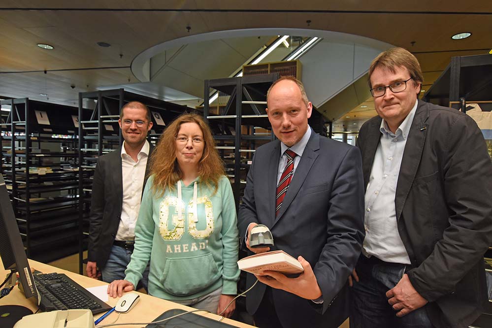 Stadt- und Landesbibliothek: Stadtrat Christian Uhr informiert sich bei Activity-Tour über Digitalisierung Anfang April war Stadtrat Christian Uhr im Rahmen seiner Activity-Tour in der Stadt- und Landesbibliothek. Dort informierte er sich unter anderem darüber, welche Vorteile Beschäftigte sowie Bürgerinnen und Bürger, die die Bibliothek nutzen, durch Neuerungen im Zuge der Digitalisierung haben. Er konnte sich unter anderem einen Überblick über den Einsatz der Radio Frequenz Identifikation (RFID) bei den Bibliotheken verschaffen. Diese Technik hat die traditionelle Verbuchung mittels Handscannern abgelöst und ermöglicht nicht nur ein schnelleres Arbeiten an den Theken sondern auch die Ausleihe und Rückgabe in Selbstbedienung. Die positiven Auswirkungen des Technikeinsatzes im Publikumsbereich in der Stadt- und Landesbibliothek und dem Institut für Zeitungsforschung waren auch Thema bei den Gesprächen, die Christian Uhr während eines Rundganges mit den Beschäftigten an ihren Arbeitsplätzen führen konnte. Die Beratung in technischen Fragen und zu den umfangreichen digitalen Angeboten der Bibliothek nimmt im Arbeitsalltag der Beschäftigten einen immer größeren Raum ein. Laufende Fortbildung und Qualifizierung wird daher immer wichtiger. Christian Uhr: „Ich freue mich, dass die Verwaltung auch in diesem Bereich in Sachen Digitalisierung bereits sehr gut aufgestellt ist. Neue Technik hilft den Beschäftigten, den Service für die Bürgerinnen und Bürger weiter zu verbessern.“