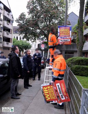 Unter den Augen von Ordnungsdezernent Norbert Dahmen und Baudezernent Arnulf Rybicki - sowie einer Gruppe Neonazis - hingen Bedienstete des Tiefbauamtes die beanstandeten Plakate auf dem Wilhelmplatz ab. 