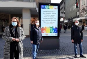 Anja Butschkau und Mirja Düwel von der AWO präsentiertenmit Cristian Kohut (Wall) die virtuellen Plakate in der City. 