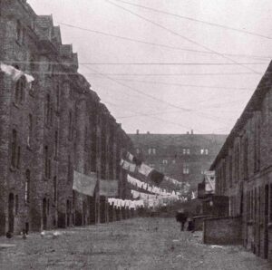 Die Ansicht von 1931 zeigt Hinterhöfe der ehemaligen Von-Busch-Straße. Die geringe Wohnqualität trug schon damals zur klischeehaften Ablehnung der Nordstadt bei. Durch den Neubau von Werkswohnungen sollten diese Verhältnisse verbessert werden.