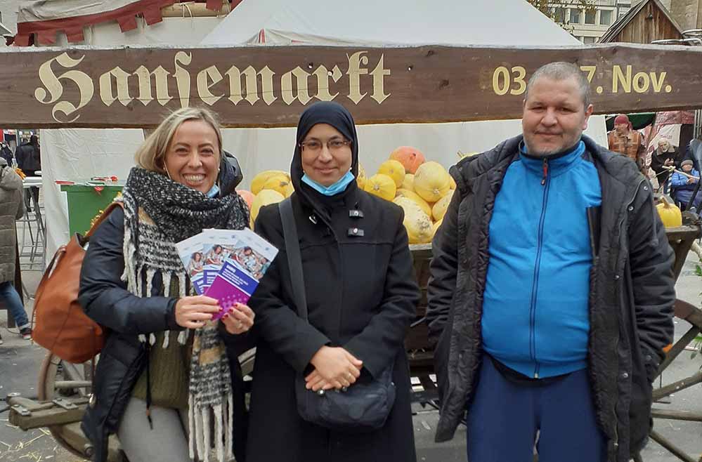 Sich in Dortmund zu Hause fühlen – (Wahl)Heimat erkunden Die Idee eines Quartierrundgangs in der Dortmunder Nordstadt kam Francesca Santo (Integrationscoach bei der dobeq GmbH) während eines Gespräches mit dem spanischen Teilnehmerpaar Houria Bakhti und Said Boulban, die ursprünglich aus Marokko stammen. Die beiden leben zwar seit 2018 in Dortmund, haben sich aber nie Zeit genommen, die Stadt Dortmund zu erkunden. Über die Gelegenheit, 2 Stunden lang die Dortmunder Nordstadt zu erschließen, welche zum Teil in der Muttersprache erfolgen kann, sind beide sichtlich erfreut. Wie viele andere ihrer Landsleute kehrten sie damals der Wirtschaftskrise und Perspektivlosigkeit in Südeuropa den Rücken und haben sich für Dortmund als Wahlheimat entscheiden. Hier in Dortmund richtig Wurzeln zu schlagen, fällt den beiden nicht leicht. Mit unserem speziell konzipierten Rundgang in der Nordstadt helfen wir unseren Teilnehmenden im Projekt DAWIQ die Dortmunder Nordstadt mit ihren zahlreichen Sehenswürdigkeiten, Angeboten und ihrer traditionsreichen Geschichte zu erschließen, um in Dortmund Wurzeln schlagen zu können. Die Stadt Dortmund hat viel zu bieten, leider wissen Neuzugewanderte sehr häufig über die Angebote nicht Bescheid und nutzen diese nicht. Wir möchten dies ändern: Die Stärkung gesellschaftlicher Partizipation, Teilhabe an niederschwelligen Qualifizierungen und Integration in faire Beschäftigung insbesondere von Neuzugewanderten in der Dortmunder Nordstadt gehören mit zu unseren Zielen im Projekt DAWIQ. Die Nordstadt-Erkundungstour bieten wir unseren Teilnehmenden sowohl auf Deutsch als auch in anderen Sprachen an: Spanisch, Italienisch, Rumänisch und Bulgarisch. Zusammen mit ihrem Kollegen, Hisen Sabedini, erarbeitet Francesca Santo eine besondere Erkundungstour für das Ehepaar, die neben den Touristen-Attraktionen Möglichkeiten auf dem Dortmunder Arbeits- und Weiterbildungsmarkt aufzeigt. Frau Bakhti war von unserer Arbeit sichtlich gerührt. Sie möchte endlich in Dortmund „richtig“ ankommen und bemüht sich sehr darum: Bei der ersten Gelegenheit hat sie sich für einen Deutschkurs angemeldet. Es ginge ihr mit dem Erwerb der deutschen Sprache nicht schnell genug, teilte die Teilnehmerin mit. Eine B2 Prüfung steht demnächst an, dies ist ein weiter wichtiger Schritt, um beruflich und privat in Dortmund durchstarten zu können. Während des Quartierrundgangs gab es einen Halt bei MIA-DO-Kommunales Integrationszentrum der Stadt Dortmund. Frau Bakhti und Herr Boulban möchten als Sprachmittler arbeiten. Aus diesem Grund hat Herr Sabedini ein kleines Treffen mit dem zuständigen Ansprechpartner seitens der Stadt Dortmund arrangiert. Als sehr freundlich und informativ empfanden die Teilnehmenden das Gespräch mit dem Verantwortlichen für den Dolmetscherpool. Am Ende des Gesprächs wussten die beiden ganz genau, wie man in den Pool der Sprachmittler aufgenommen werden kann, erklärte Said. Der Quartiersrundgang geht weiter, auf unserer Strecke finden sich auch bereits bekannte Orte, wie die Verbraucherschutzzentrale, welche dem Ehepaar von ihren Freunden bereits als besonders hilfreich empfohlen wurde. Sehr groß sei die Stadt Dortmund, sagt Herr Boulban, dies bestätigt Frau Bakhti als der Blick auf die Fußgängerzone fällt. Dennoch erreicht man mit den öffentlichen Verkehrsmitteln jeden Winkel der Stadt, da es ein gut aufgebautes Netz gibt, lobt Said. Er fühle sich in Dortmund sehr wohl und liebe besonders die Vielfältigkeit der Stadt Dortmund. Als die geplanten 120 Minuten um sind, zieht es uns alle noch kurz zu dem Weihnachtsmarkt hin, wo gerade ein Ritterkampf von Schaustellern inszeniert wird. Viel zu schnell verging die Zeit, sagen beide mit einem Lachen und freuen sich weiter auf einen Spaziergang zu weit. Es war ein Rundgang mit vielen bekannten Orten, die von dem Ehepaar neu entdeckt wurden, und neuen Einrichtungen, die sie aufsuchen, wenn Sie Hilfe zur Selbsthilfe benötigen. „Wir würden sehr gerne unsere Erkundungstour mit einer Gruppengröße von 10-12 Menschen anbieten, da wir einen großen Bedarf unter unseren Teilnehmenden identifiziert haben. Der Arbeitsmarkt in Dortmund hat sich in Folge der Corona-Pandemie verändert: die Arbeitsuchenden müssen sich neu orientieren. Allerdings macht uns auch hier Corona einen Strich durch die Rechnung: Wir bieten den Quartiers-Rundgang unter der strengen Einhaltung der Corona-Schutzmaßnahmen an; eine größere Gruppe ist dabei leider nicht möglich“, sagt Hisen Sabedini. „Ich kann den Wunsch meines Teams, das Angebot für möglichst viele Teilnehmende im Projekt DAWIQ zu öffnen, sehr gut nachvollziehen. Aktuell nutzen wir die Führungen mit einem Haushalt dazu, Erfahrungen zu sammeln und den neuen Ansatz weiterzuentwickeln. Ich finde es schön, dass mein Team den Corona bedingten Änderungen mit neuen kreativen Lösungsansätzen begegnet. Sobald es möglich ist, werden wir Erkundungstouren mit größeren Gruppen anbieten, um gesellschaftliche Teilhabe und Chancen auf eine nachhaltige Arbeitsmarktintegration bei unseren Teilnehmenden zu stärken. Nur so können wir zu einer vielfältigen Gesellschaft gelangen, die durch Stärken und Kompetenzen jedes Einzelnen bereichert wird und Gewinn für alle ihre Mitglieder darstellt“, fügt Yulia Stevenson, Projektleiterin für den Bereich Angebote für Zugewanderte, hinzu. DAWIQ – Digitale Wirtschaft, faire Arbeit und gutes Wohnen in der Dortmunder Nordstadt ist ein lokales und sozialräumlich orientiertes Verbundprojekt, gefördert im Bundes/ESF-Programm Bildung, Wirtschaft, Arbeiten im Quartier (www.biwaq.de). Projektträger in Dortmund ist das Amt für Angelegenheiten des Oberbürgermeisters und des Rates „nordwärts vor ort“ in Kooperation mit der GrünBau gGmbH und der dobeq GmbH als Teilprojektträgerinnen. Zielgruppe bei den Teilprojektträgerinnen sind (Neu-)Zugewanderte EU-Bürger*innen ab 27 Jahren sowie Langzeitarbeitslose, mit und ohne Migrationshintergrund, insbesondere aus der Dortmunder Nordstadt. Ursprünglich wurde das Projekt DAWIQ für den Zeitraum vom 01.01.2019 bis zum 31.12.2021 bewilligt, da der Bedarf weiterhin so hoch ist, wurde das Projekt bis zum 31.12.2022 verlängert.