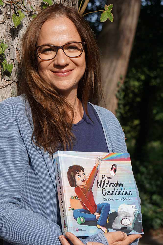 Das Zahnsammel-Buch „Meine Milchzahn-Geschichten - die etwas andere Zahndose“ der Dortmunder Zahntechnikerin Ketti Gnida ist mit völlig neuem Design in neuer Auflage erschienen. „Ich wollte Eltern und Kindern das Album auch in einem klassisch-modernen Kinderbuchdesign anbieten“, sagt Ketti Gnida, die inzwischen neben ihrer Arbeit als Zahntechnikerin bei einem Dortmunder Zahnarzt, mit ihrer Freundin einen Verlag für ihre Buchprojekte gegründet hat. Die Zeit im Corona-Lockdown hat die Dortmunderin dafür genutzt, das „Buch zum Sammeln von Zähnen und ihren Geschichten“ mit der Kinderbuch-Grafikerin Saskia Diederichsen umzugestalten. Das bewährte Prinzip des Buches bleibt dabei erhalten: Die ausgefallenen Milchzähne werden in einzelne Fächer eines Zahnrades am Ende des Buches gelegt. Mit dem Rad können sie zu den Albumseiten mit Guckloch gedreht werden, auf die Kinder und ihre Eltern die persönliche Geschichte zu jedem Zahn selbst aufschreiben und bebildern können. „Die wunderschönen Geschichten und Erinnerungen von Zähnen sollen einfach nicht verloren gehen“, sagt die Zahntechnikerin. Ob es der ausgeschossene Zahn im Fußballtor ist oder die erste Zahnlücke bei der Einschulung: „Es sind bleibende Kindheitserinnerungen, die zu schade für eine normale Zahndose sind.“ Ketti Gnida selbst wollte als Mutter vor fünf Jahren den Geschichten und Zähnen, auf die sie und ihre Söhne so stolz waren, einen persönlichen Ort geben. 2016 entstand so in Zusammenarbeit mit dem Dortmunder Künstler Osman Xani die erste Auflage von „Meine Milchzahngeschichten“, die die Dortmunderin seitdem über ihre Webseite, im Online-Handel und einigen Buchhandlungen vertreibt. Die vielen Rückmeldungen von Eltern haben sie ermutigt, ihre Buch-Idee mit einem neuen Design noch breiter zu streuen. „Das Buch wird im Kreis der Familie immer wieder hervorgeholt, auch von älteren Kindern“, sagt Ketti Gnida. „Es ist für alle, die Spaß beim Sammeln von Erinnerungen haben.“ Die Neuauflage kann ab sofort unter www.milchzahn-geschichten.de bestellt werden. Dort gibt es auch noch Exemplare des 2016er-Designs. In Dortmund ist das Buch zudem bei Lotto Krebin im Rewecenter Rheinische Straße erhältlich.