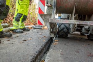 Beim Trenching wird mittels einer Fräse ein schmaler Graben oder Schlitz durch den asphaltierten Straßenoberbau in den Untergrund gefräst.