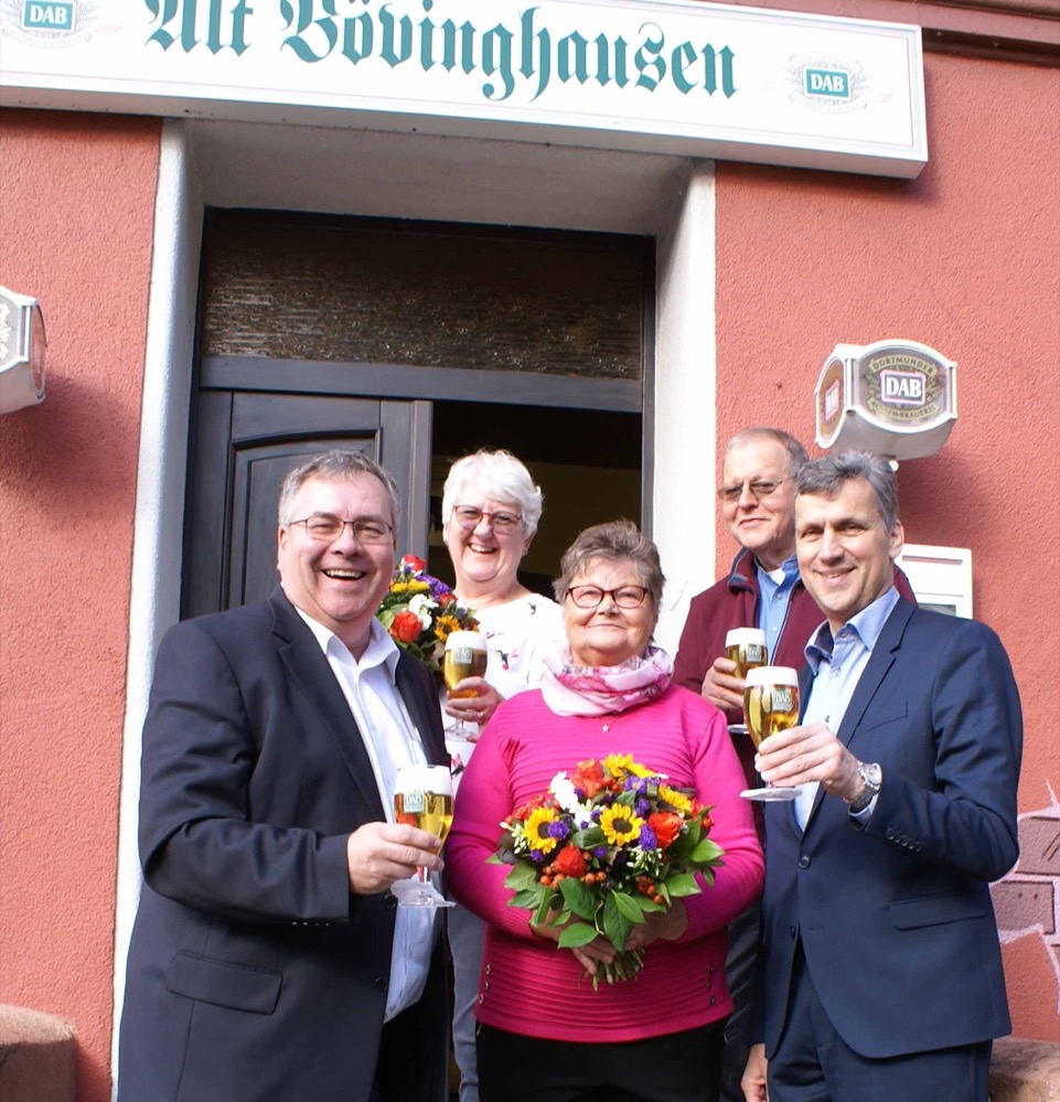 Eine besondere Tradition lebt weiter! Die urige Kneipe „Alt Bövinghausen“ mit Wirtin Wilma Wünsch feiert ihr 100-jähriges Jubiläum und es ist noch kein Ende in Sicht… Seit nunmehr 51 Jahren betreibt das „gastronomische Dortmunder Urgestein“ Wilma Wünsch ihre bierige Kneipe. Von sich selbst sagt die langjährige Wirtin: „Das Alt Bövinghausen ist mein Leben.“ Und ihr Vermieter Karl Kowalke, Sohn und Enkel der vorherigen Gastronomen, ergänzt mit einem Augenzwinkern: „Du hörst nicht auf, bis du die älteste Wirtin von Dortmund bist!“ Vor genau hundert Jahren kauften die Eheleute Margrethe und Gustav Kowalke, Großeltern von Karl Kowalke dem heutigen Besitzer, das Haus an der Bockenfelder Straße, um fortan die Bövinghausener Bürger mit frisch gezapften Dortmunder Bier und leckeren, kulinarischen Kleinigkeiten zu versorgen. „Französische Besetzer nach dem ersten Weltkrieg, amerikanische und britische Alliierte nach dem zweiten Weltkrieg, Kohle- und Stahlarbeiter und sogar ein lebendiges Pferd vergnügten sich einst im Schankraum“, weiß Karl Kowalke aus eigenen Erlebnissen und Erzählungen zu berichten. „Bei uns war immer was los!“, schwärmt der Hauseigentümer und freut sich, dass Wirtin Wilma Wünsch noch lange das DAB-Bier durch den Zapfhahn fließen lassen möchte… Eine besondere Tradition lebt! Wirtin Wilma Wünsch (Mitte) stößt mit Hauseigentümern Gabriele und Karl Kowalke, Jörg Seelig (li.) und Thomas Schneider (re.) von den Dortmunder Brauereien auf das 100-jähriges Jubiläum im „Alt Bövinghausen“ an.