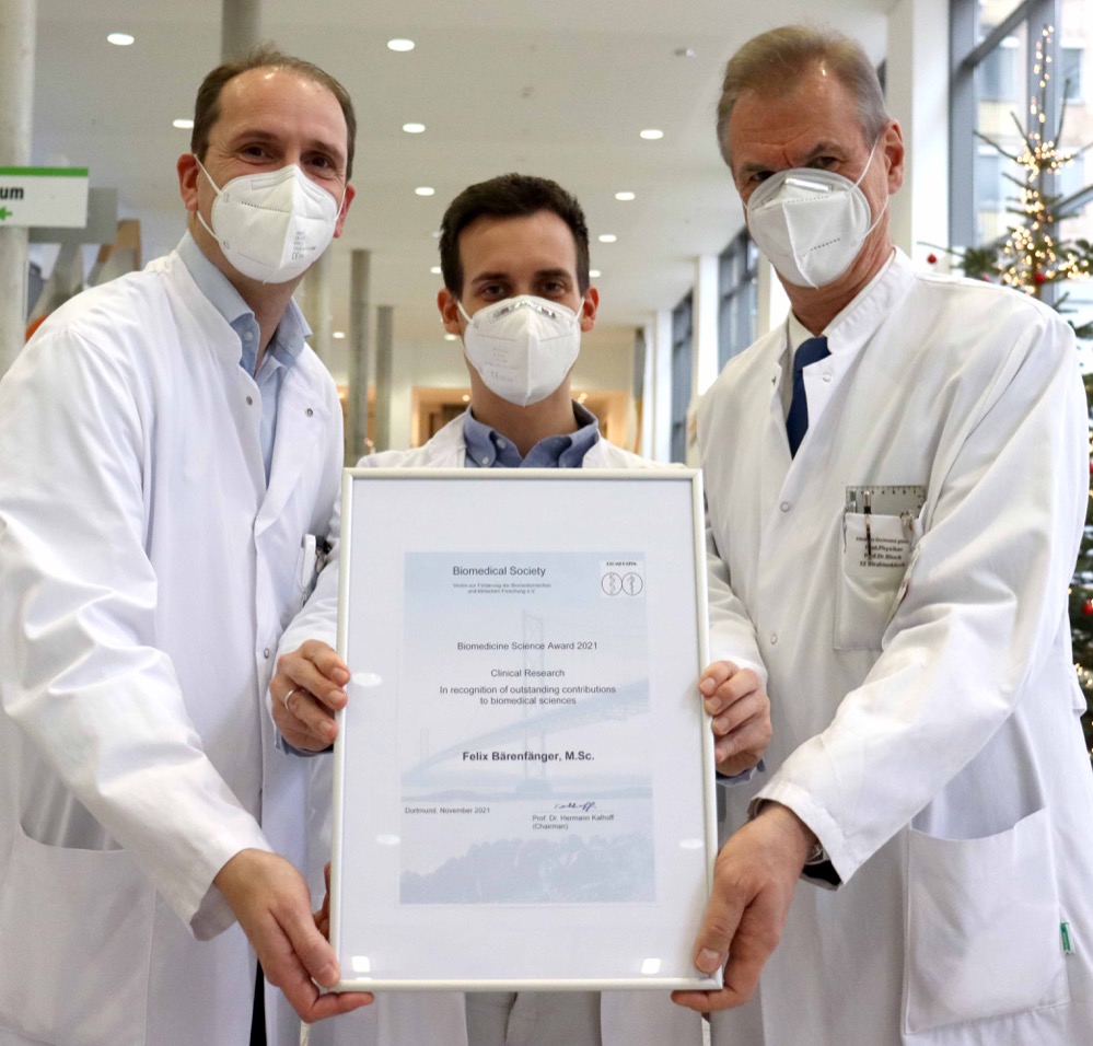Der Medizinphysik-Experte Felix Bärenfänger aus dem Klinikum Dortmund hat jetzt den Förderpreis der Biomedizinischen Gesellschaft Dortmund gewonnen. Das Foto zeigt ihn mit Prof. Dr. Stefan Rohde (links; Direktor der Klinik für Radiologie und Neuroradiologie) und Prof. Dr. Andreas Block (Direktor des Instituts für Medizinische Strahlenphysik und Strahlenschutz) im Klinikum Dortmund. Der Medizinphysik-Experte Felix Bärenfänger ist jetzt mit dem Förderpreis 2021 der Biomedizinischen Gesellschaft Dortmund ausgezeichnet worden. Damit würdigt die Jury seine praxisnahe Forschungsarbeit zur Dosisbelas- tung von Untersucher und Patienten bei der Behandlung von Schlaganfall- Patienten. Bärenfänger nämlich, der am Institut für Medizinische Strahlen- physik und Strahlenschutz (Prof. Dr. Andreas Block) im Klinikum Dortmund arbeitet, hatte ein Verfahren entwickelt, das es ermöglicht, aus den erfass- ten Untersuchungsdaten das Risiko von strahlenbedingten Hautreaktionen des Patienten abzuschätzen (nachzulesen in „Investigation of Radiation Exposure of Patients with Acute Ischemic Stroke during Mechanical Thrombectomy“, Röfo – Thieme Verlag). In einem zweiten Schritt wurden die Geräteeinstellungen soweit optimiert, dass sich die Dosis und das damit verbundene Risiko für Hautreaktionen um ca. 50% reduzieren lässt. Zur weiteren Dosisreduktion für das medizinische und pflegeri- sche Personal testete das Team um Prof. Stefan Rohde, Direktor der Klinik für Radiologie und Neuroradiologie, und Felix Bärenfänger in einem Anschlusspro- jekt moderne Strahlenschutz-Systeme für den Kopf des Untersuchers. „Ich freue mich sehr über diese große Ehre, allein schon, weil ich mit meinen Forschungs- arbeiten anwenderorientiert eine echte Verbesserung erreichen konnte und dies nun im universitären Umfeld auf so positive Resonanz stößt“, sagt Bärenfänger. Der Biomedizin-Förderpreis will praxistaugliche medizinische Innovationen her- vorheben und damit Benchmarks für außergewöhnliche Leistungen in der For- schungsarbeit setzen. Worum geht es in dem Forschungsgebiet von Felix Bärenfänger? Neuro- Radiologen können heutzutage mittels feiner Bohr-Instrumente Blutklumpen im Hirn von Akut-Schlaganfall-Patient:innen entfernen und sie damit quasi von ihrem Hirnschlag heilen. Dieser Eingriff, der ein wenig an das „Entkorken“ einer Flasche erinnert, nennt sich Thrombektomie und wird unter Röntgenstrahlung vorgenom- men. Das heißt, die behandelnden Mediziner:innen sehen über Bildschirme an Live-Röntgenbildern, wo sie sich gerade im Kopf des Patienten befinden. Hier sind Wissenschaftler:innen, wie Bärenfänger, in der Entwicklung von Techniken aktiv, die die Strahlendosis für Patient:innen sowie Ärzt:innen und Pflegekräfte während des Eingriffs auf ein notwendiges Minimum reduzieren. Das Tückische daran ist, dass diese Strahlung unsichtbar und mit keinem menschlichen Sinnesorgan zu erfassen ist. Moderne Dosis- Managementsysteme, die die Strahlendosis für den Patienten streng überwa- chen, sind seit Änderung der Strahlenschutzgesetzgebung Ende 2018 unum- gänglich geworden. Die genaue Erfassung sowie die Reduktion der Dosis für Patient und Untersucher gehören dabei zu den Aufgaben des klinisch arbeiten- den Physikers. Prof. Rohde ist stolz auf diese Forschungsergebnisse aus dem eigenen Klinikum: „Sie ermöglichen es uns, unseren Mitarbeitenden bei derartigen Eingriffen am Patienten künftig noch mehr Sicherheit zu geben.“ Gerade, weil derartige Eingrif- fe zunehmen, sei dies ein echter Vorteil. Felix Bärenfänger ist übrigens auch als Dozent in den vom Klinikum angebotenen Strahlenschutz-Kursen für Ärzt:innen aktiv und gibt dort sein Wissen an die Mediziner:innen weiter.