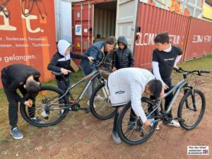 Gemeinsam mit den Kindern und Jugendlichen werden die neuen Fahrräder montiert.