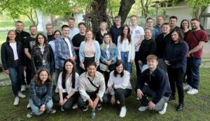 Gruppenfoto der Auszubildenen und Delegationsteilnehmer*innen im Garten der Internationalen Jugendbegegnungsstätte Oświęcim.