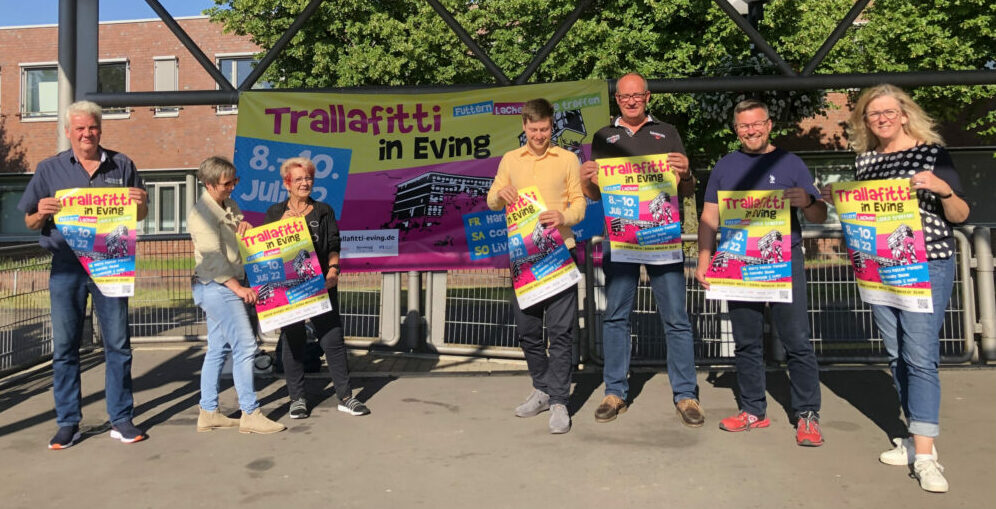 Jürgen Mohr, amtierender Bezirksbürgermeister Oliver Stens und weitere vor dem Banner des "Trallafitti in Eving"