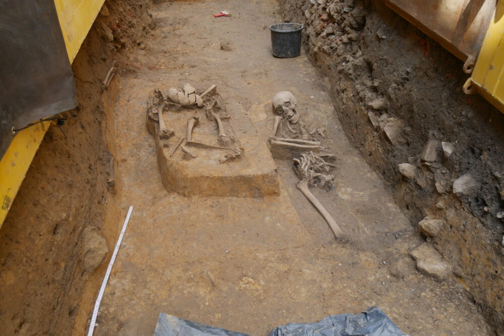 Zwei der gefundenen Skelette. Weitere menschliche Knochen sind in der linken Seitenwand zu sehen.