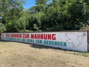 Das Wandbild von Anna Hauke erinnert seit 2021 zusätzlich zum Gedenkstein an die Deportation der Sinti:zze und Rom:nja
