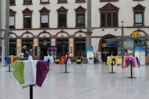 Zum CSD und der Ausstellung „pain pride pose" sind die Stehtische mit den Pride Flaggen zugedeckt.