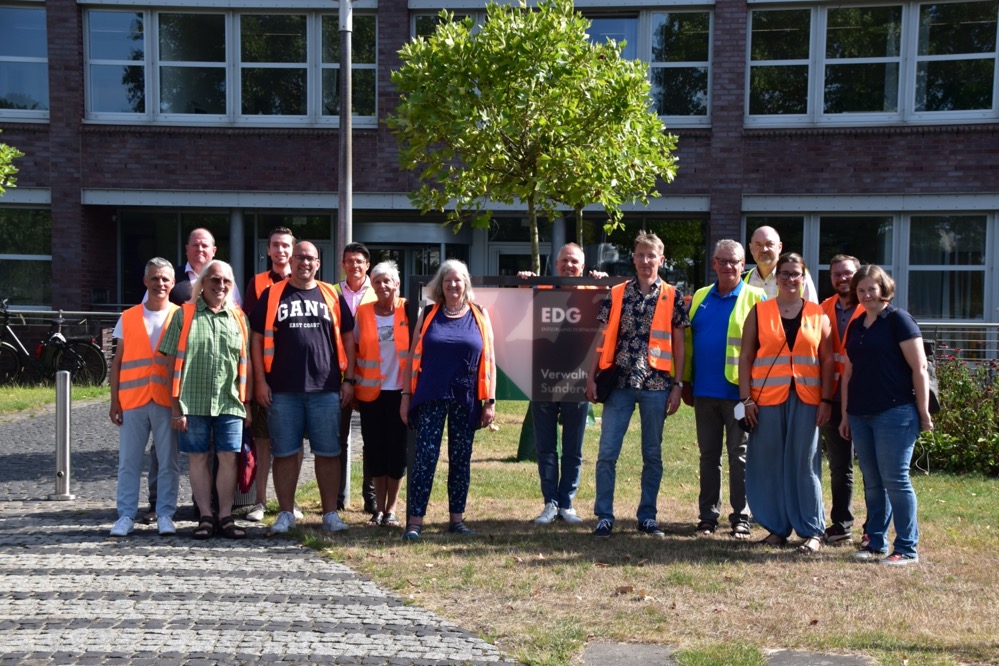 SPD-Ratsfraktion zu Gast bei der EDG – kritischer Blick auf den anstehenden gebührenfreien Sperrmülltag Auf ihrer Sommertour hat die SPD-Ratsfraktion einen Stopp bei der städtischen EDG Entsorgung Dortmund GmbH eingelegt. Hier informierten sich die Ratsmitglieder insbesondere über die Entwicklung des Grünflächeninformationssystems, den anstehenden gebührenfreien Sperrmülltag und die aktuelle Lage bei der EDG. „Seit der Übernahme der Pflege des Straßenbegleitgrüns durch die EDG hat sich das Stadtbild entlang der Straßen positiv entwickelt und die „Reinigung aus einer Hand“ funktioniert. Auch wenn die EDG vor Herausforderungen etwa durch den demografischen Wandel bei den Mitarbeiter*innen oder durch die allgemeine aktuelle Situation steht, sind wir positiv gestimmt, dass die EDG ihre Arbeit in gewohnter Qualität fortsetzt. Mehr noch erwarten wir, dass die EDG ihren eingeschlagenen Weg im Bereich Klimaschutz weiter vorantreibt. Als SPD-Fraktion wollen wir die EDG weiter positiv unterstützen“, erklärt die Sprecherin der SPD-Fraktion im Ausschuss für Mobilität, Infrastruktur und Grün, Gudrun Heidkamp. Nach der Übernahme der Pflege des Straßenbegleitgrüns durch die EDG stand die EDG vor der Aufgabe 4,43 Millionen Quadratmeter Grünfläche, bestehend aus über 45.000 Einzelflächen, für die Pflegemaßnahmen zu strukturieren und mögliche Hindernisse zu erfassen. Dies erfolgte über den Aufbau des sogenannten Grünflächeninformationssystems, durch das es der EDG möglich ist, die Pflegemaßnahmen des Straßenbegleitgrüns zu optimieren, um so z.B. Arbeitszeit oder CO2-Emissonen einzusparen. Dieses Grünflächeninformationssystem konnten die Ratsmitglieder bei dem Termin kennenlernen. „Mit einem kritischen Auge blicken wir auf den angekündigten gebührenfreien Sperrmülltag, der nun nacheinander in jedem Stadtbezirk durchgeführt werden soll. Diesen hatten wir in dieser Form im Rat abgelehnt. Die auf den ersten Blick positiven Aspekte des gebührenfreien Sperrmülltags werden unserer Ansicht nach durch die zu erwartende Verschmutzung, Arbeitsbelastung und insbesondere durch die entstehenden Kosten überlagert. Am Ende müssen diese Kosten von der Stadtkasse oder zukünftig über die Gebühren zusätzlich getragen werden und belasten die Dortmunder Bürger*innen. Der Sperrmülltag ist eben nicht kostenlos. Hier werden wir bei der Evaluation des gebührenfreien Sperrmülltages ein genaues Auge draufwerfen. Eine dauerhafte zusätzliche Belastung lehnen wir ab“, erklärt der finanzpolitische Sprecher der SPD-Ratsfraktion, Fabian Erstfeld, abschließend zu dem Termin.