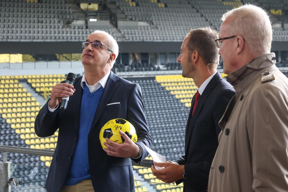 TU-Rektor Prof. Manfred Bayer, Moderator Christoph Edeler und BVB-Geschäftsführer Thomas Treß begrüßen die „Erstis“ im Stadion. Den Ball mit Autogrammen des aktuellen BVB-Kaders schoss Bayer in die Menge.