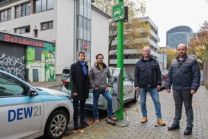 Darüber, dass die Menschen in Dortmund nun auch an 320 Laternen ihre E-Fahrzeuge laden können, freuen sich Meinolf Pflug, Fachkoordinator Straßenbeleuchtung beim Tiefbauamt der Stadt Dortmund, Tim Psztur und Marcel Nierhoff (Technischer Service, Beleuchtungsservice bei DEW21), und Carsten Henderkott, Projektleiter bei SPIE.