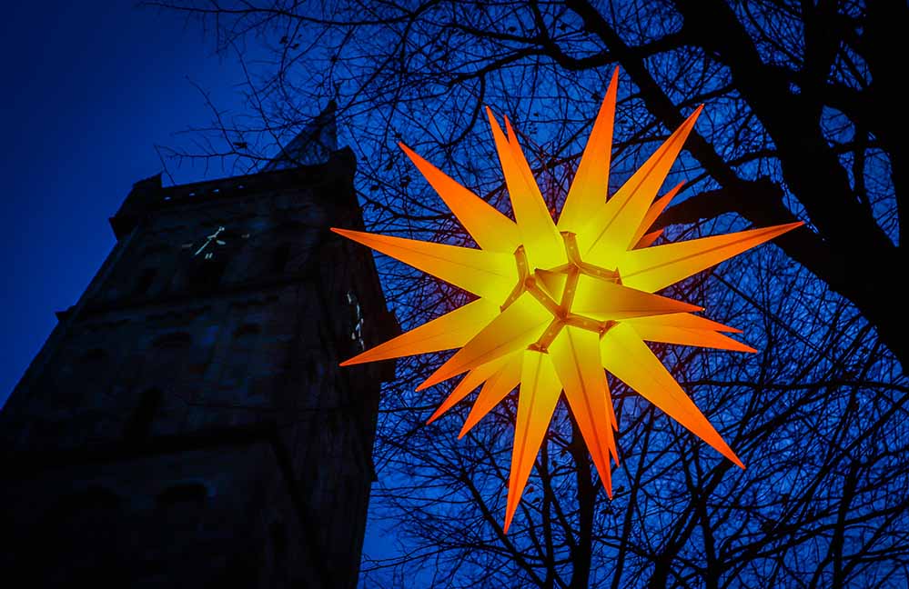 Ein großer Stern leuchtet vor der Evangelischen Kirche in Lütgendortmund. (Archivbild)