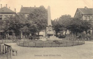 Der Kaiserbrunnen vor dem Ersten Weltkrieg. Im Hintergrund Häuser an der Kaiserstraße.