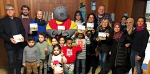 Gruppenbild mit Maskottchen Plappermaul sowie Kinder- und Jugenddezernentin Monika Nienaber-Willaredt (3. v.li. hinten), Jan Hendrik Schröder (stellv. Leiter des Jugendamts, 2.v.li. hinten), Pfarrer Friedrich Stiller (hinten links), Gesa Harbig (re., St. Antonius), Heike Klumbies (FABIDO-Kita Bornstraße, 5.v.li.) und Ulrike Dreps (Friedens-Grundschule Marten, 7.v.re.)