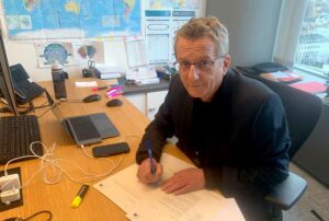 Dietmar Köster, wie er die Briefe an die Außenministerin und den Botschafter unterzeichnet. 